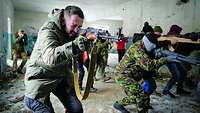 Ukrainische Soldaten trainieren Zivilisten an Waffenattrappen und bereiten diese auf den Kampf vor. 
