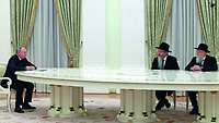 Wladimir Putin am langen weißen Tisch mit dem Oberrabbiner und Präsidenten der Föderation der Jüdischen Gemeinden Russlands