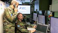 Zwei Soldaten arbeiten in einer Kabine des mobilen Kommunikationssystems der Bundeswehr.