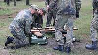 Soldaten bauen aus Holzbrettern und leeren Kanistern ein Floß.
