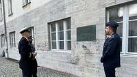 Drei Offiziere stehen im Ehrenhof der Gedenkstätte Deutscher Widerstand in Berlin und blicken auf eine Gedenktafel