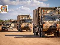 Konvoi aus militärischen Fahrzeugen auf einer Sandstraße