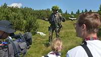 Ein Soldat spricht zu Reportern, die mit Kameras vor ihm stehen.
