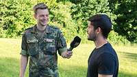 Ein Soldat mit Mikrofon im Interview mit einem Experten