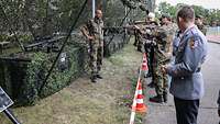 Soldaten und ihre Angehörigen schauen sich Waffen der Bundeswehr an.