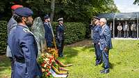 Ein General und ein Zivilist stehen vor dem Stauffenberg-Gedenkstein. Zwei Kränze wurden niedergelegt.