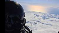 Ein Pilot im Eurofighter-Cockpit schaut in die Kamera. Am Boden sieht man das vereiste Island.