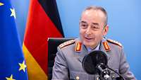 Generalinspekteur der Bundeswehr General Carsten Breuer sitzt vor einem Mikrofon.
