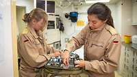 Zwei Soldatinnen prüfen die Medikamente, die sich in Rettungsrucksäcken befinden