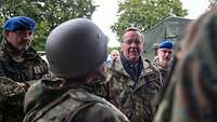 Verteidigungsminister Boris Pistorius steht vor einem Soldaten mit Helm