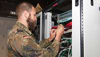 Soldat verdrahtet einen IT-Schaltschrank