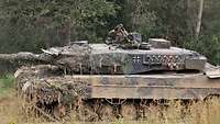 Ein tschechischer Soldat steht vor einem Leopard 2 und weist dem Kommandanten den Weg. 