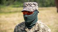 A Ukrainian serviceman standing in front of a field