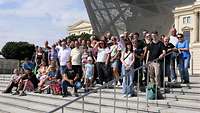 Mehrere Personen haben sich zu einem Gruppenbild auf einer Treppe aufgestellt.