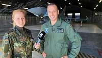 Zwei Soldaten posieren für ein Foto mit Eurofighter im Hintergrund