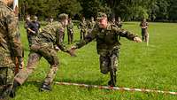 Zwei Soldaten klatschen sich bei einem Wettlauf ab