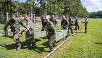 Eine Gruppe Soldaten trägt mehrere Kisten