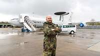 Junger Soldat steht auf dem Rollfeld, im Hintergrund ein E-3A Awacs-Aufklärungsflugzeug der NATO.