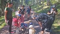 Kinder und Erwachsenen auf einem Wanderweg durch einen Wald