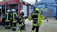 Mehrere Feuerwehrleute mit Ausrüstung machen sich auf den Weg in ein Dock