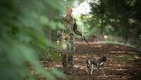 Hauptfeldwebel Jennifer M. geht mit ihren zwei Hunden im Wald spazieren