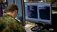 Ein Soldat sitzt vor einem PC