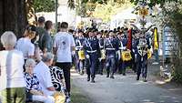 Stabsmusikkorps marschiert ein zum Gelöbnis, Gäste stehen am Rand