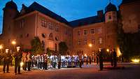 A military orchestra in front of a castle at nightfall