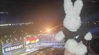 Ein Hase posiert vor der Veranstaltungsbühne auf der gerade das deutsche Team begrüßt wird.