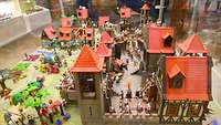 Eine Playmobil Ritterburg mit vielen Häusern und Figuren zum Anschauen.