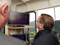 A man is looking at a screen in a cable car.