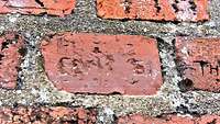 Der Name Elvis ist in einem roten Mauerstein geritzt.