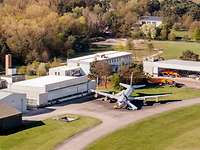 Aerial view of several buildings. In front of them, there is a large aircraft.