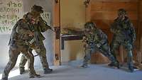 Je zwei Soldaten stehen rechts und links an einer Tür, einer rechts öffnet gerade die Tür.
