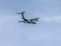 A large aircraft flies with the cargo ramp open.