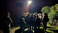 Eine Gruppe von Soldaten steht nachts an einem Gebäude
