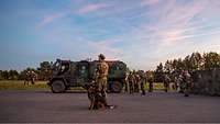 Mehrere Soldatinnen und Soldaten sowie ein Diensthund stehen um das Bundeswehr-Fahrzeug YAK.