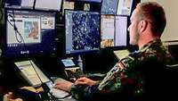 A tactical air command and control sergeant checks the air situation picture using many computer screens.