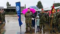 Soldaten mit Familien stehen mit anderen auf einem großen Platz