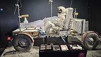 Ein Astronaut sitzt in dem Original einesMondautos.