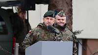 Zwei polnische Soldaten stehen an einem Rednerpult.
