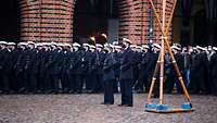 Menschen in Schwarzen Uniformen werden auf dem Alten Markt in Stralsund vereidigt.