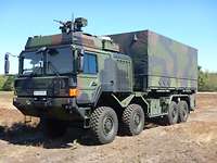 A truck with camouflage paint in open terrain