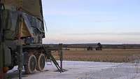 Ein militärisches Fahrzeug mit Radar steht auf einer Betonplatte.