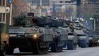 Mehrere Panzer stehen auf einer Straße, die beiden im Vordergrund sind Schützenpanzer Puma.
