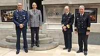 Gruppenfoto mit drei deutschen und einem ausländischen Soldaten vor einem Gebäude.