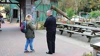 Eine Frau spricht mit einem Marinesoldaten, im Hintergrund steht eine Scheune.