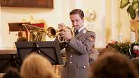 Ein Musiker des Heeresmusikkorps spielt Trompete.
