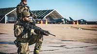 Zwei bewaffnete Soldaten bewachen einen Flugplatz 