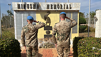 Zwei Soldaten salutieren vor einer Gedenktafel mit der Aufschrift „Minusma Memorial“ 